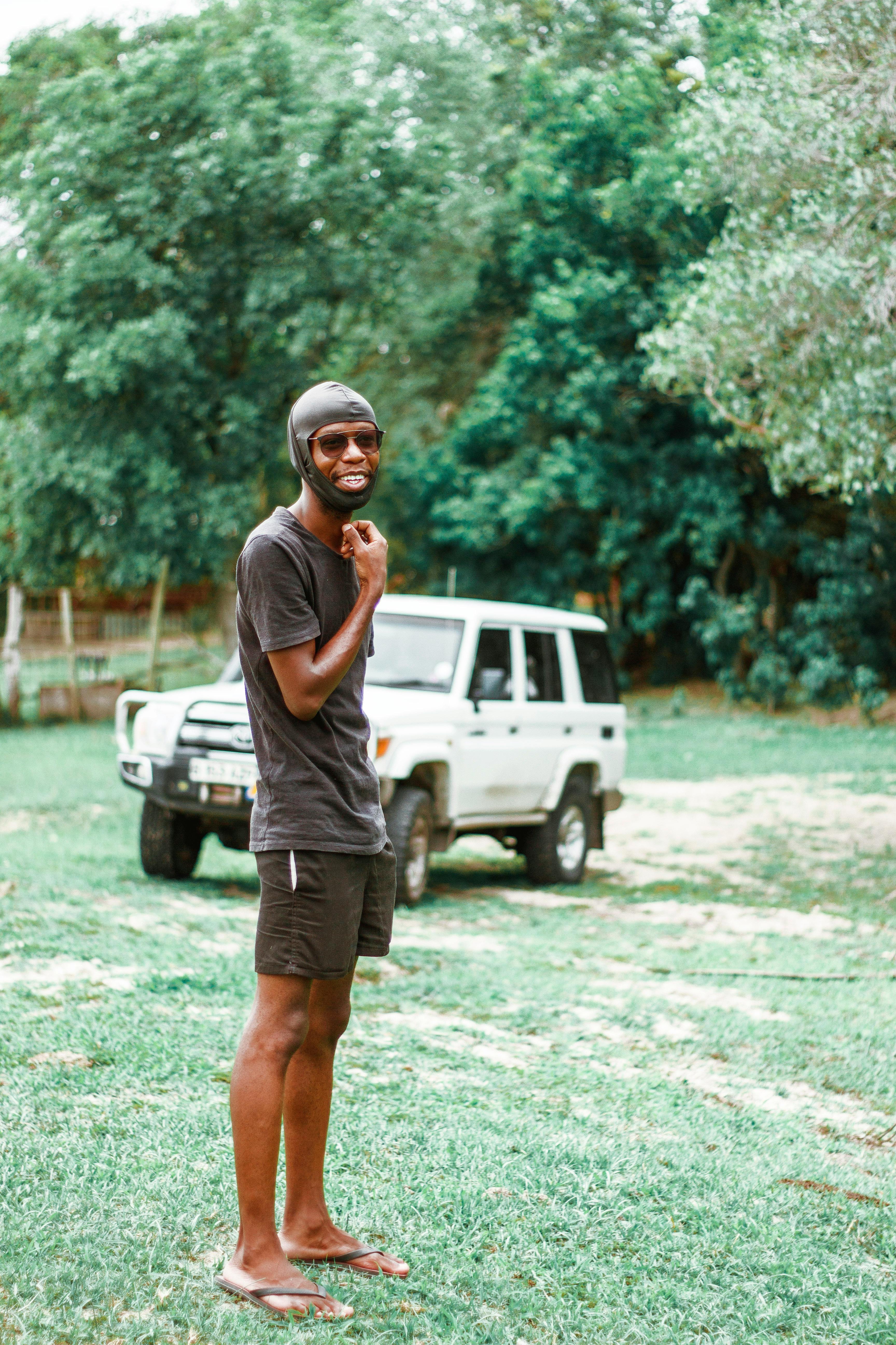 a man in grey t shirt standing on green grass