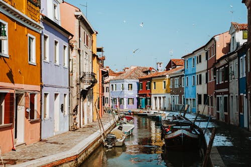 Boats on Water Canal in Between Colorful Houses