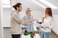 Woman in White Long Sleeve Shirt Holding White Printer Paper