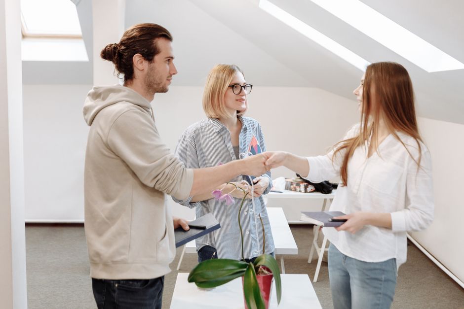Tres compañeros de trabajo participan en una reunión de negocios en interiores, mostrando trabajo en equipo y acuerdo.