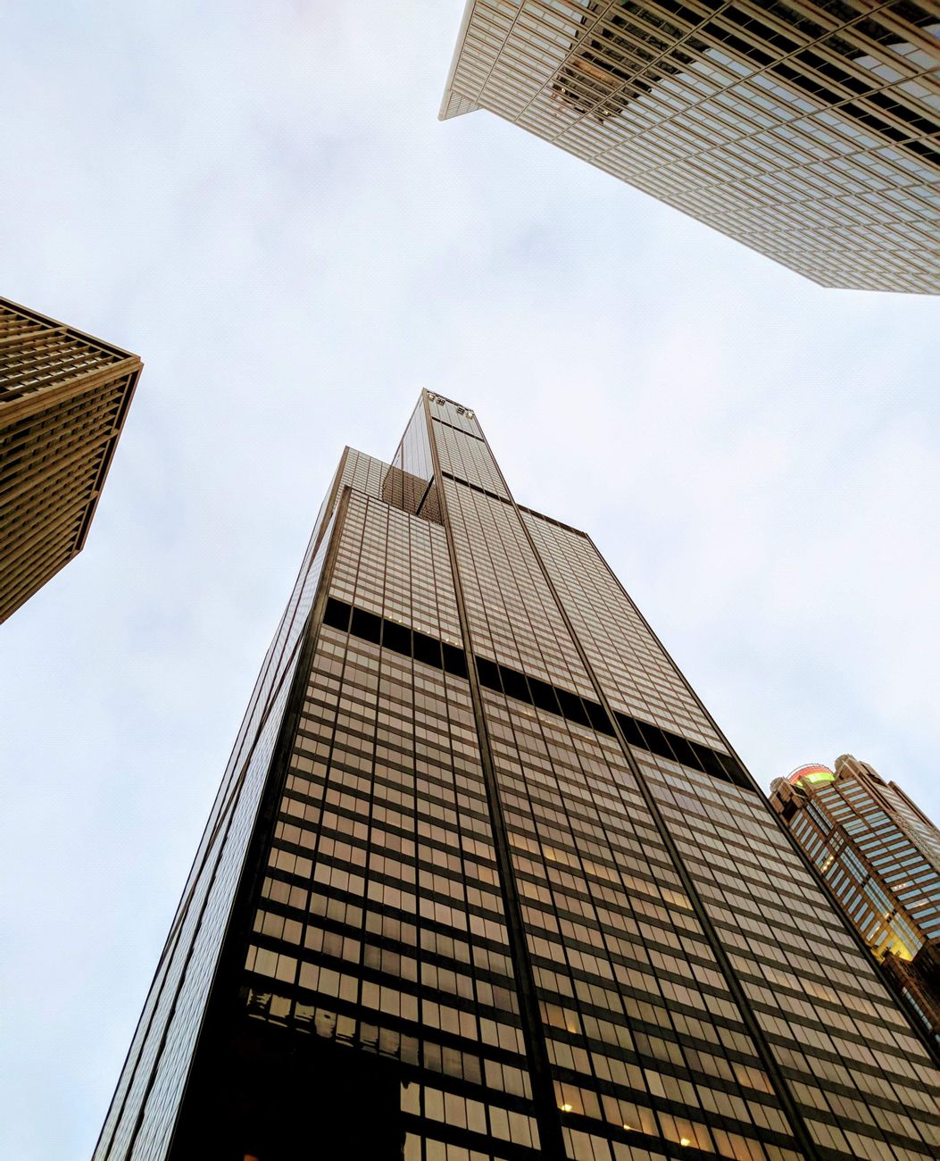Low angle view of towering skyscrapers under a cloudy sky, emphasizing modern architecture.