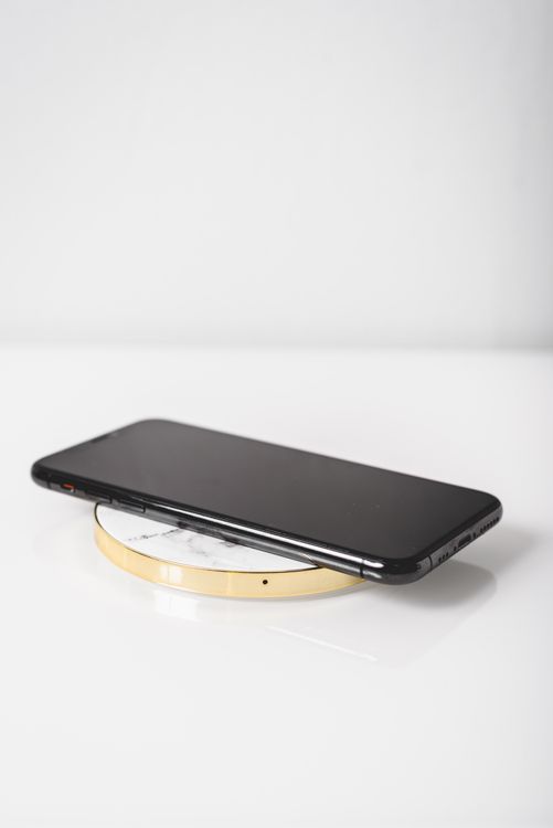 Smartphone on a wireless charger on a clean white surface