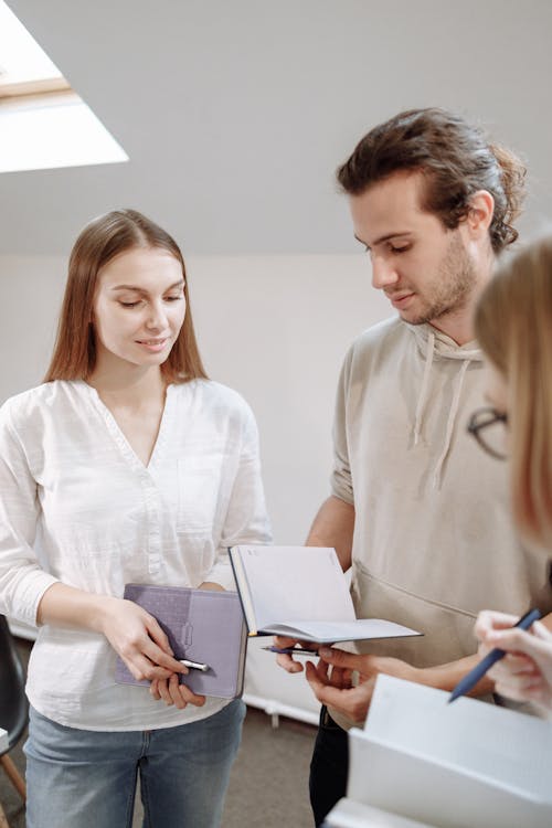 Free People Holding Notebooks and Pens Stock Photo