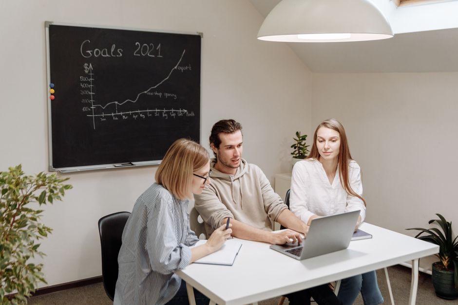 Colegas de trabalho colaboram em um ambiente de escritório moderno, planejando e discutindo as metas para 2021.