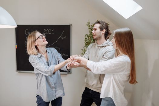 Young coworkers celebrate success with joy and teamwork indoors.