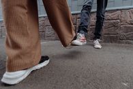 特写镜头中，街道上保持社交距离的人们用脚打招呼