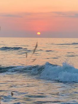 Tranquil sunset view over the sea in Greece, capturing the serene beauty of nature and ocean waves.