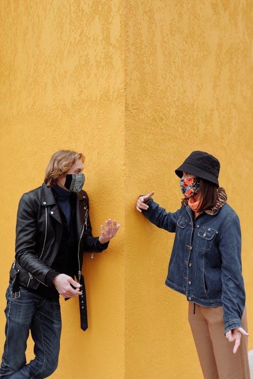 A Man and a Woman in Face Masks Having a Conversation