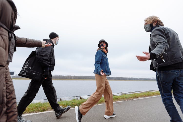 People Wearing Jacket And Facemasks Walking Together 