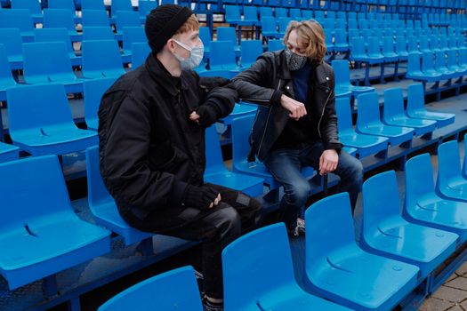 Man in Black Jacket Sitting on Blue Gang Chair