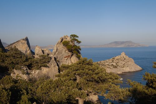 Free Captivating view of rock formations and the calm sea at sunrise, perfect for nature lovers. Stock Photo