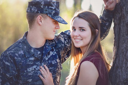 A Couple Standing Beside the Brown Tree Trunk