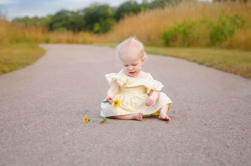 Free A Girl in Yellow Dress Sitting on the Street Stock Photo