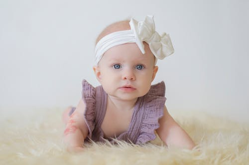 A Portrait of a Baby in Purple Dress