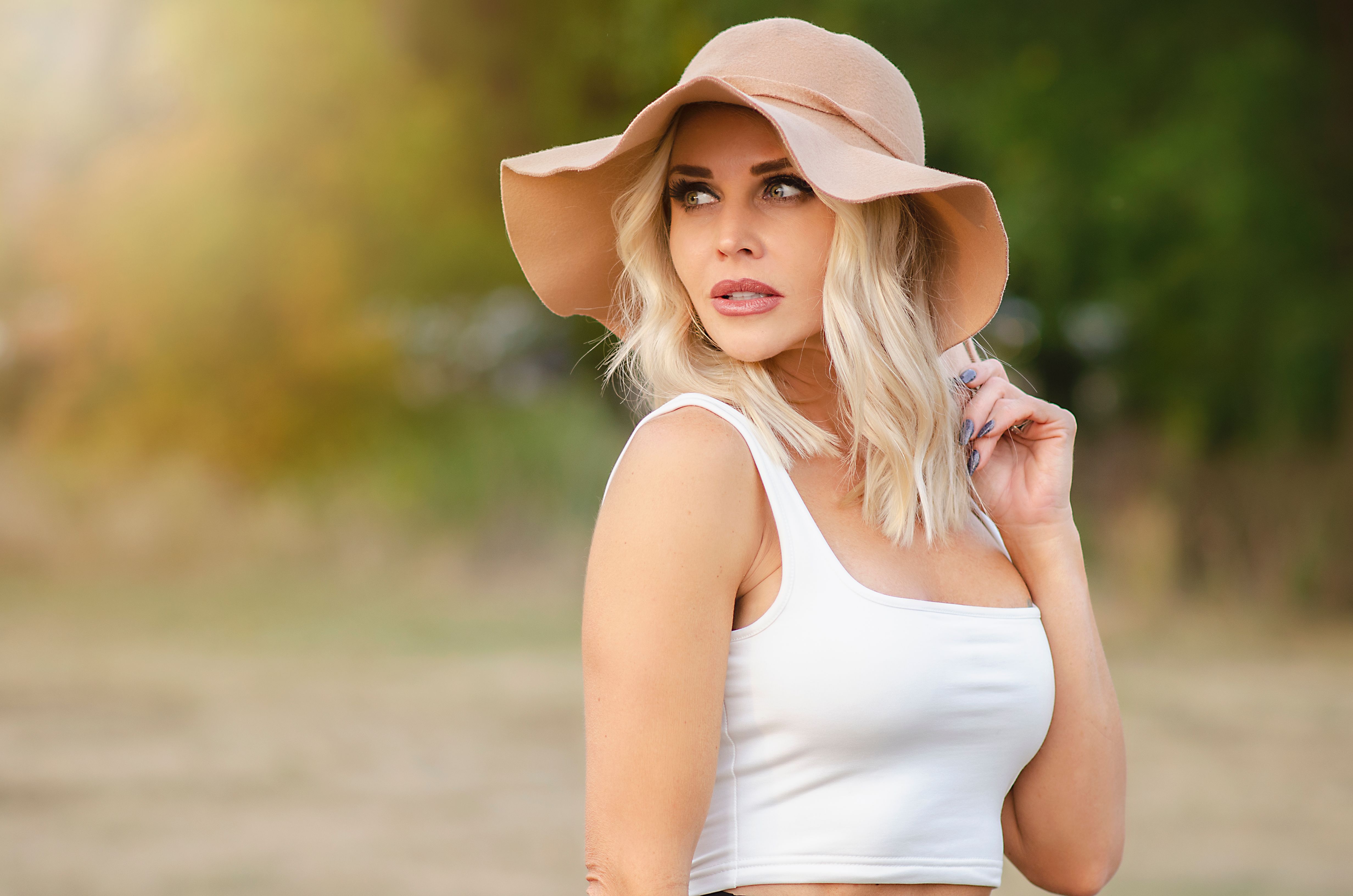 Una mujer con un top corto blanco y un sombrero