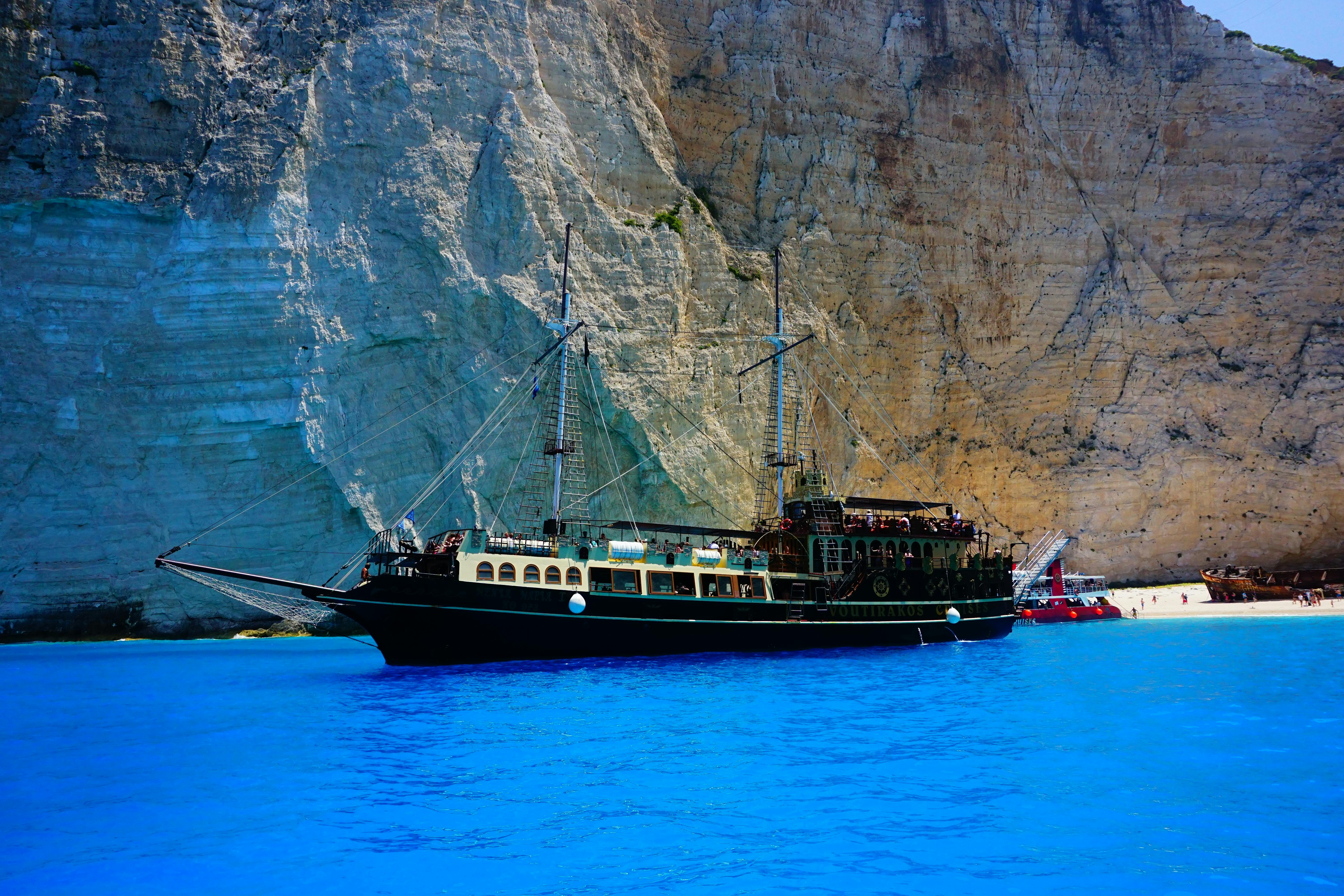 Black Ship at Sea Near Rock Formation \u00b7 Free Stock Photo