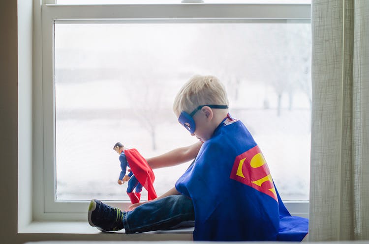 A Boy Wearing A Superman Costume