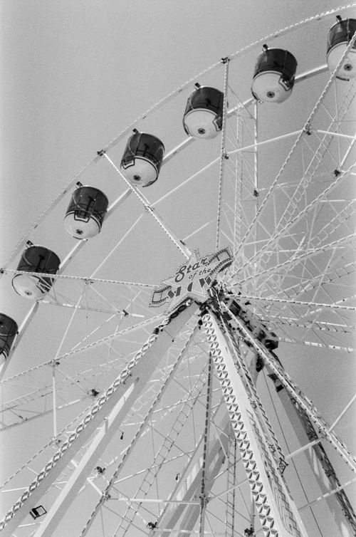 Free From below of big ferris wheel on background of cloudless sky in amusement park Stock Photo