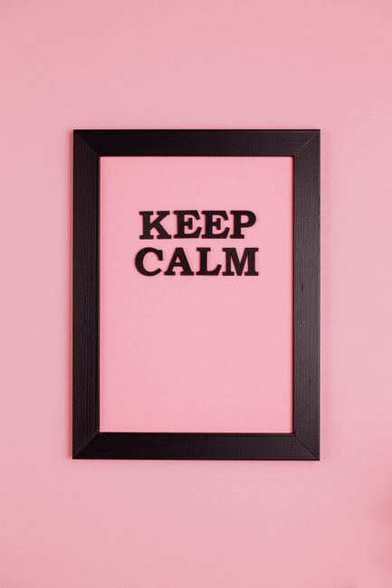 Minimalist black frame with 'Keep Calm' text on a vibrant pink wall, offering a calming aesthetic.