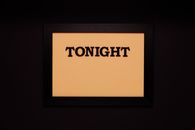 Minimalist framed sign with the word 'Tonight' on a solid black background.