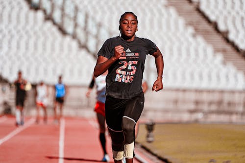 Man in Black Shirt Running on Track Field