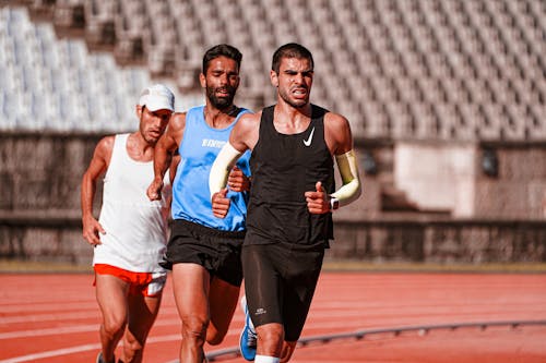 Free Men Running on a Running Track Stock Photo