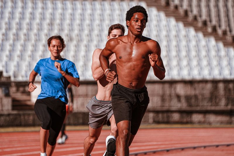 Grupo de atletas entrenando en una pista al aire libre