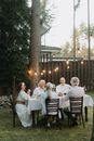 People Sitting on Brown Wooden Chairs with Table Covered with White Textile