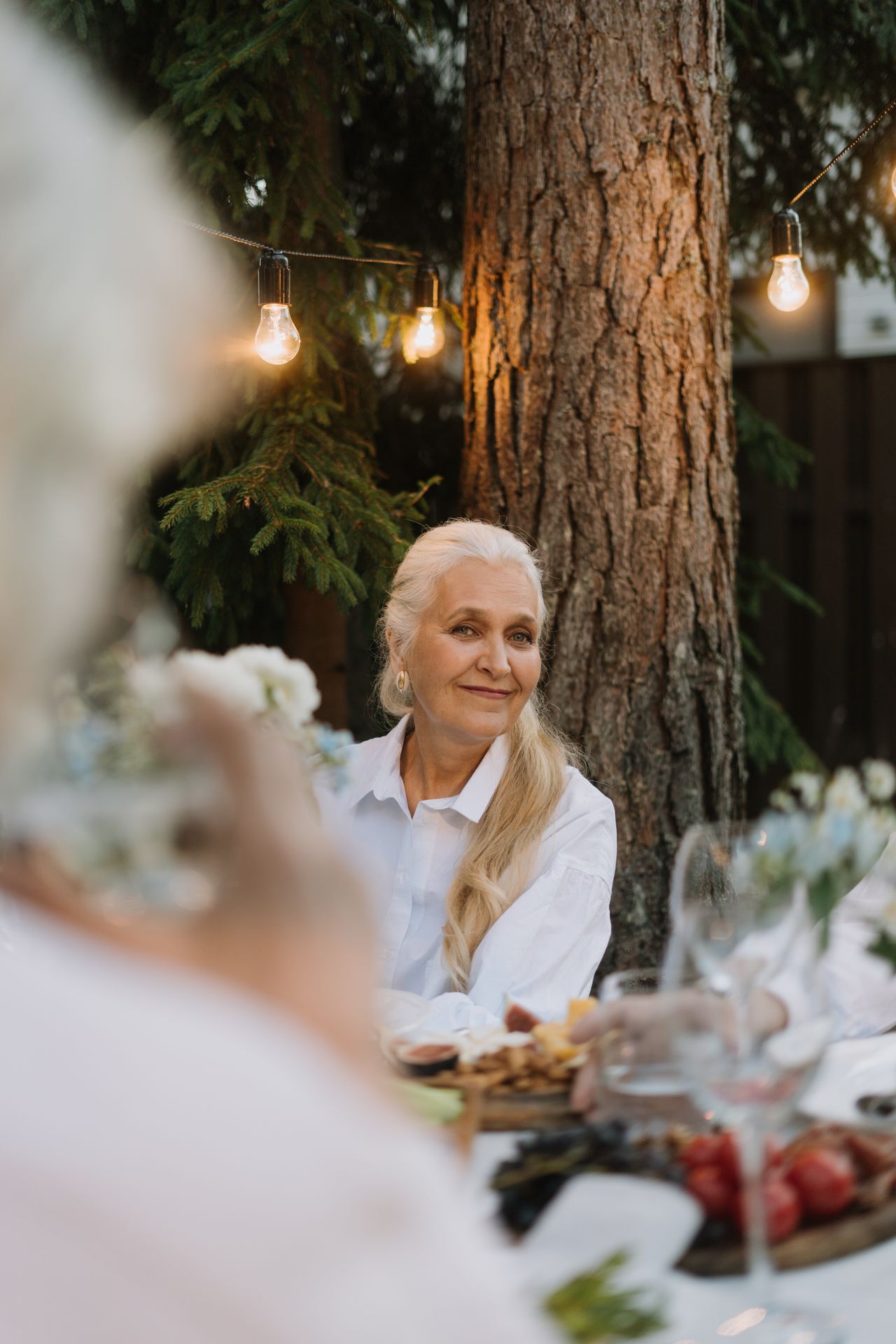 A guest seated at an outdoor dinner table