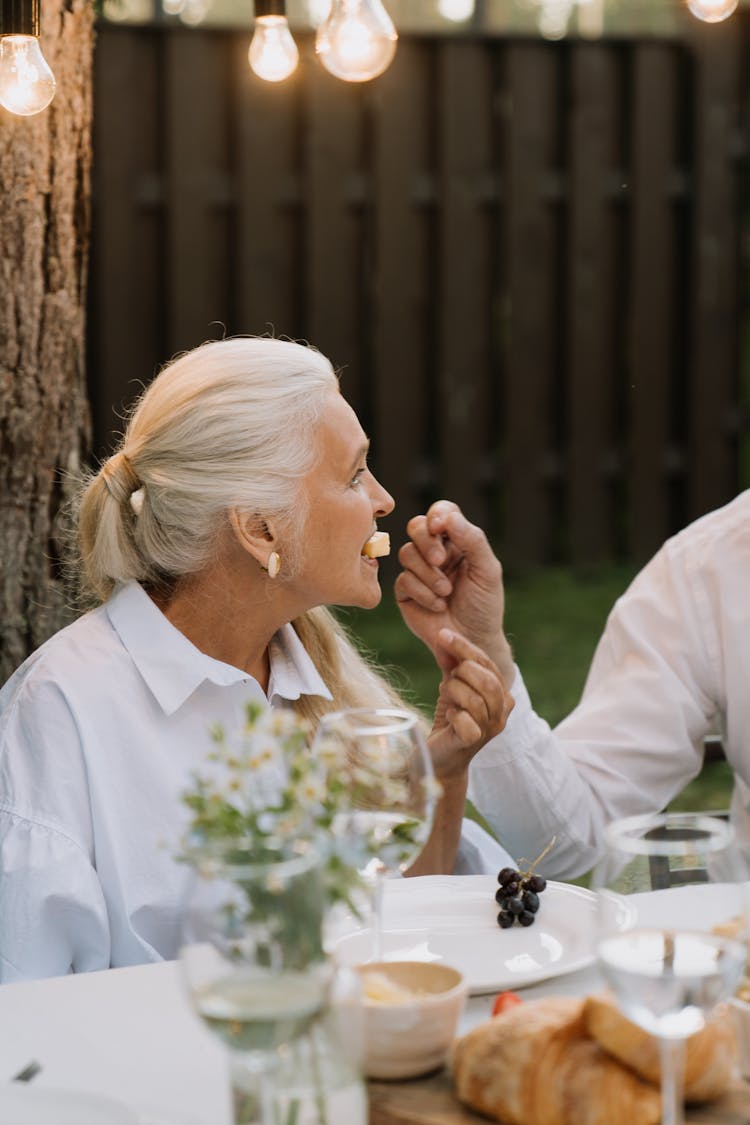 A Woman In White Dress Eating Cheese