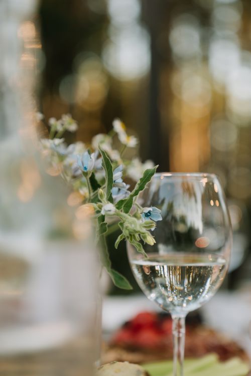 Free Close-up of a wine glass and delicate flowers on a table setting, perfect for outdoor gatherings. Stock Photo