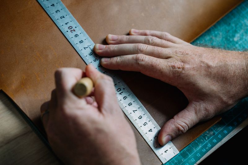 Measuring a leather panel with a ruler before repair