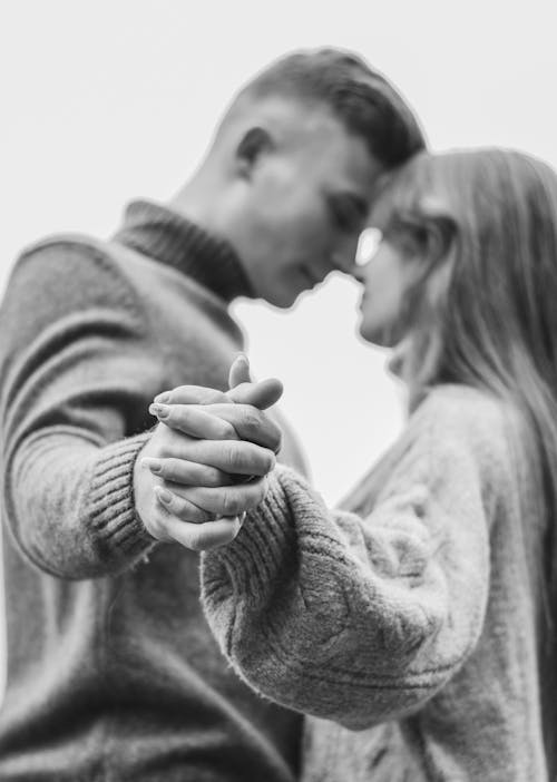 Grayscale Photo of Man and Woman Holding Hands