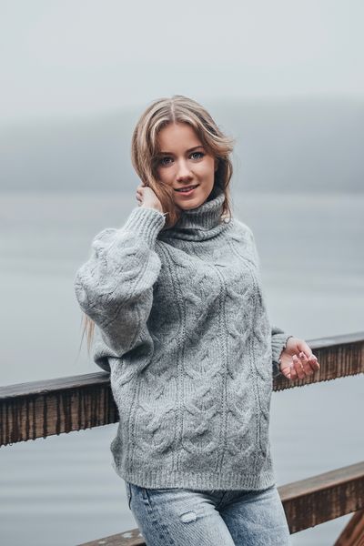 Grey cable-knit jumper worn by the lake — photo by Diana Jefimova on Pexels