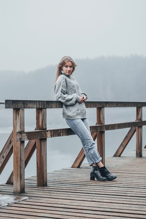 Woman Standing on a Pier on a Foggy Day 
