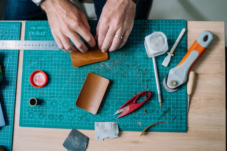 Person Holding Brown Leather Material