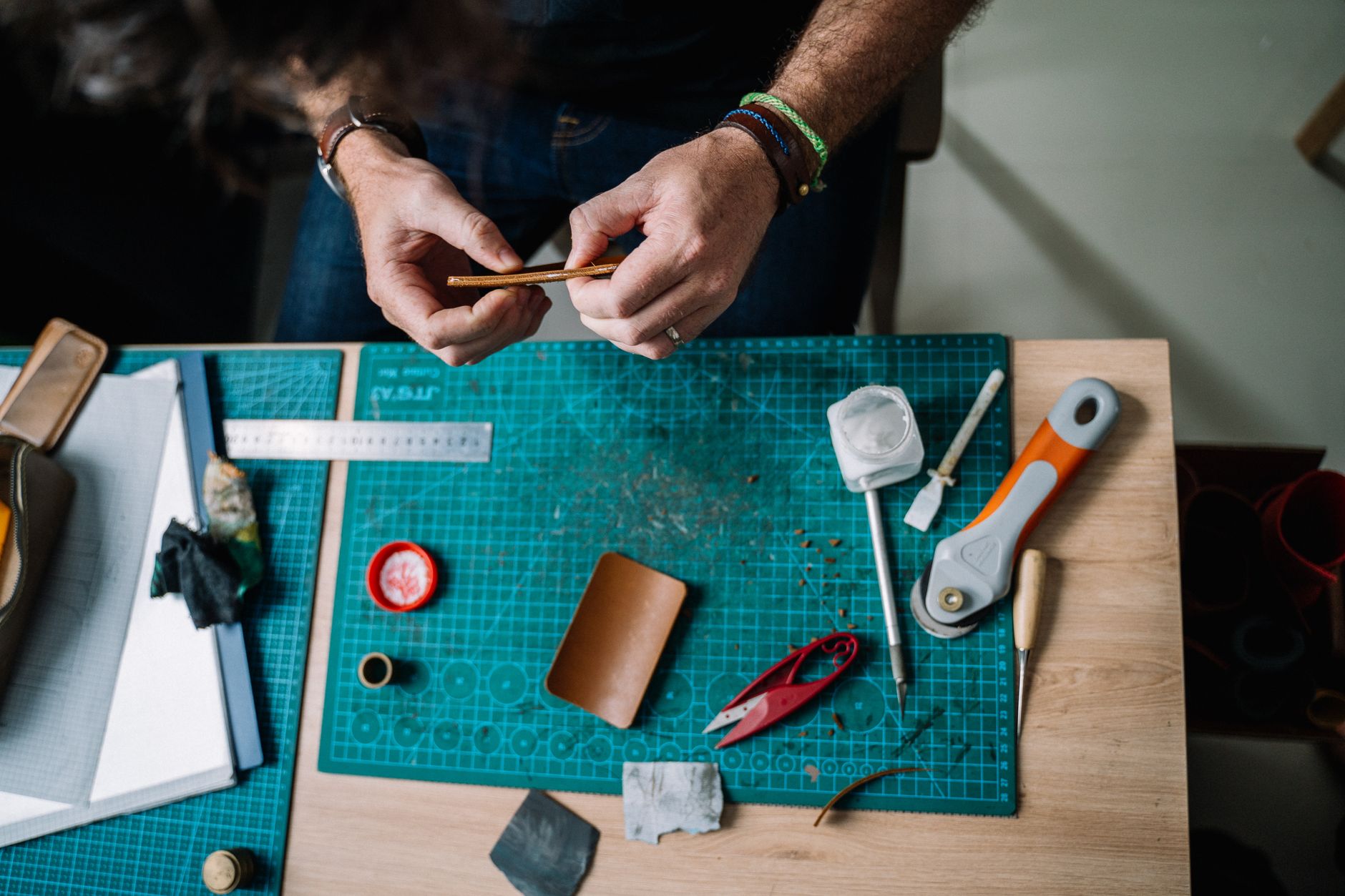 Artisan crafting leather by hand with traditional tools in a Florence workshop