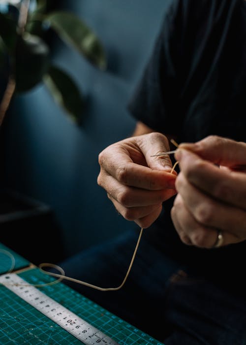 Person Holding Thread and Needle 