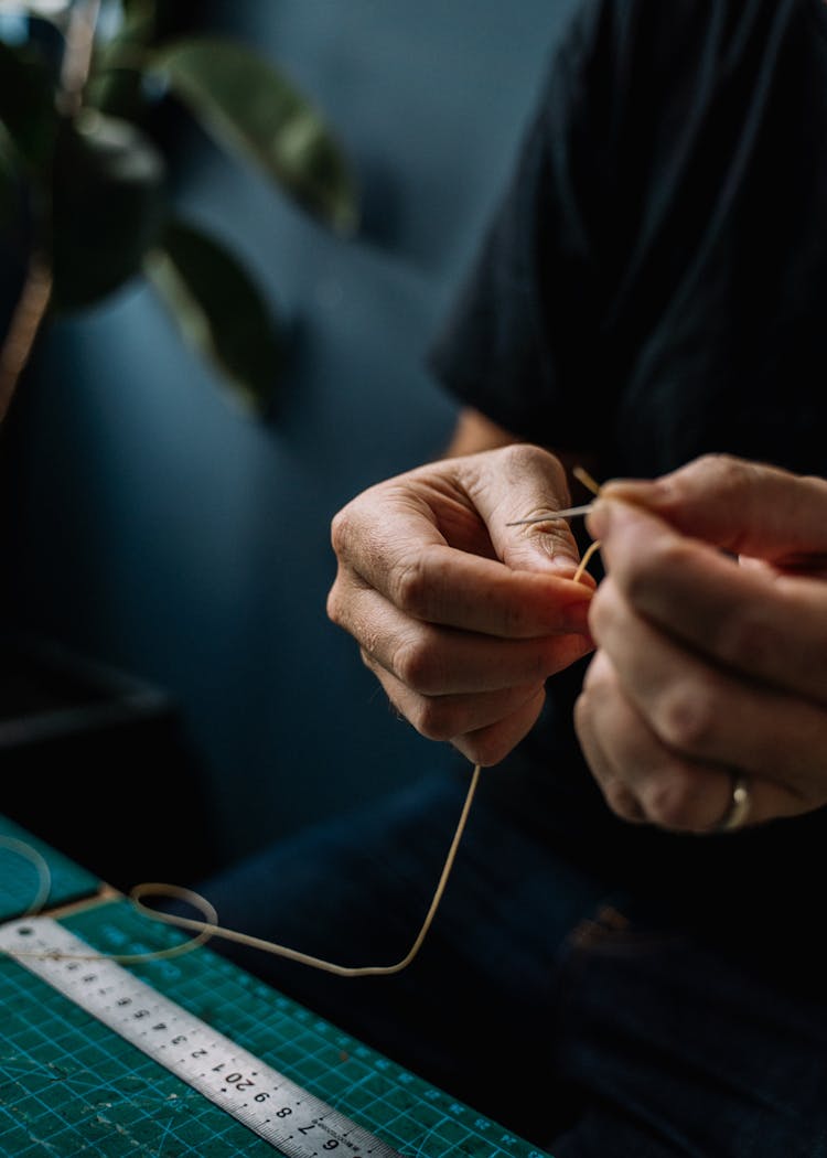 Person Holding Thread And Needle 