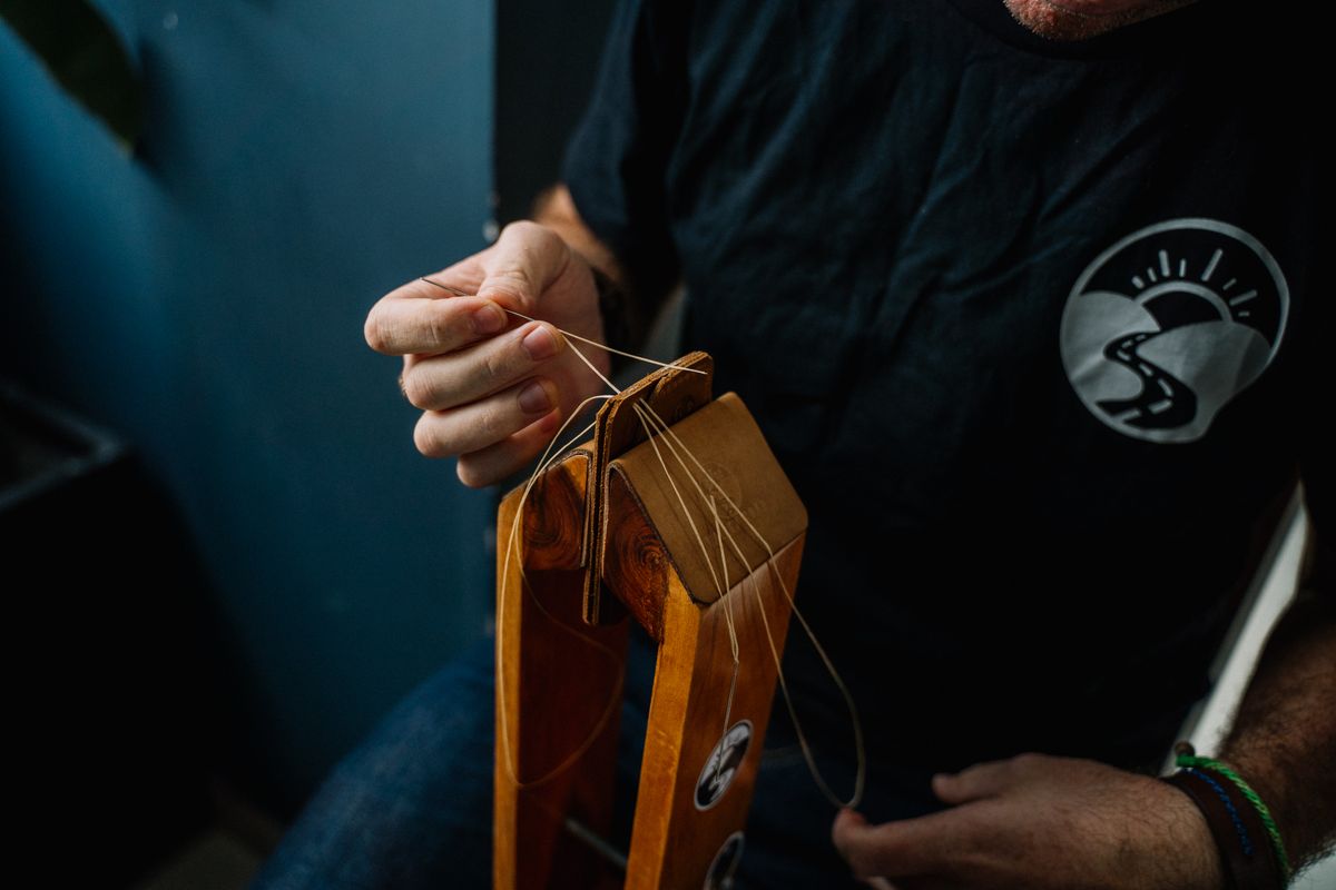Maker stitching a leather wallet by hand