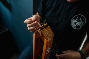 Craftsman stitching a leather wallet by hand