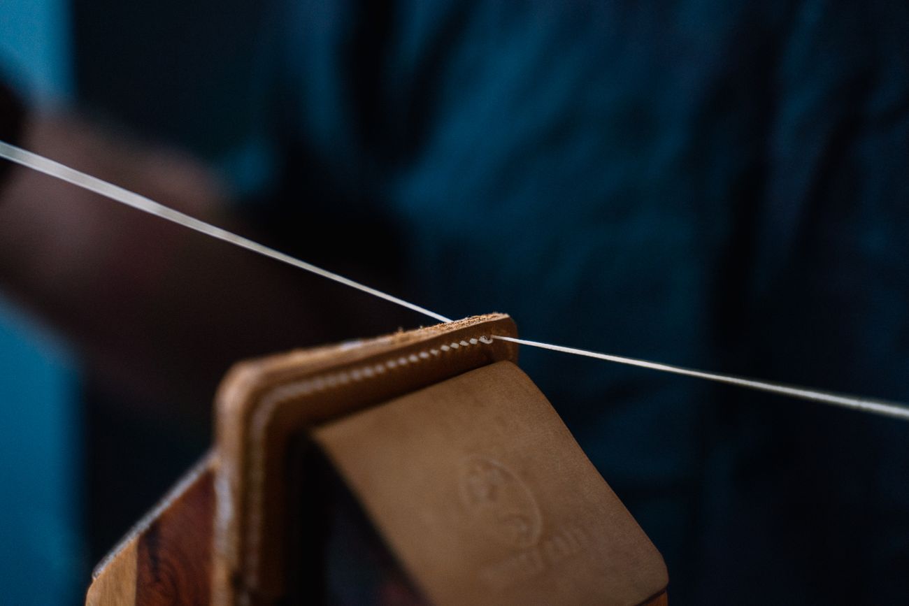 Close-up of a handmade leather piece being saddle-stitched by hand — photo by Anna Tarazevich on Pexels