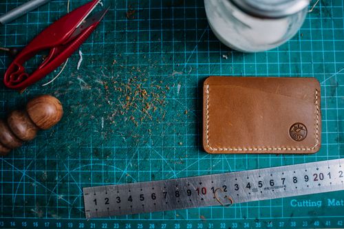 Free Top view of a crafting work table with leather wallet and tools, showcasing artisanship. Stock Photo