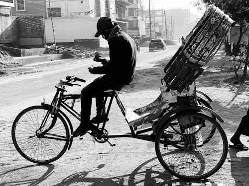 Black and White Rickshaw Driver Taking Break