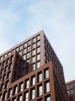 这是一座现代化的高层建筑，其引人注目的砖砌立面上装有面向晴朗天空的大窗户