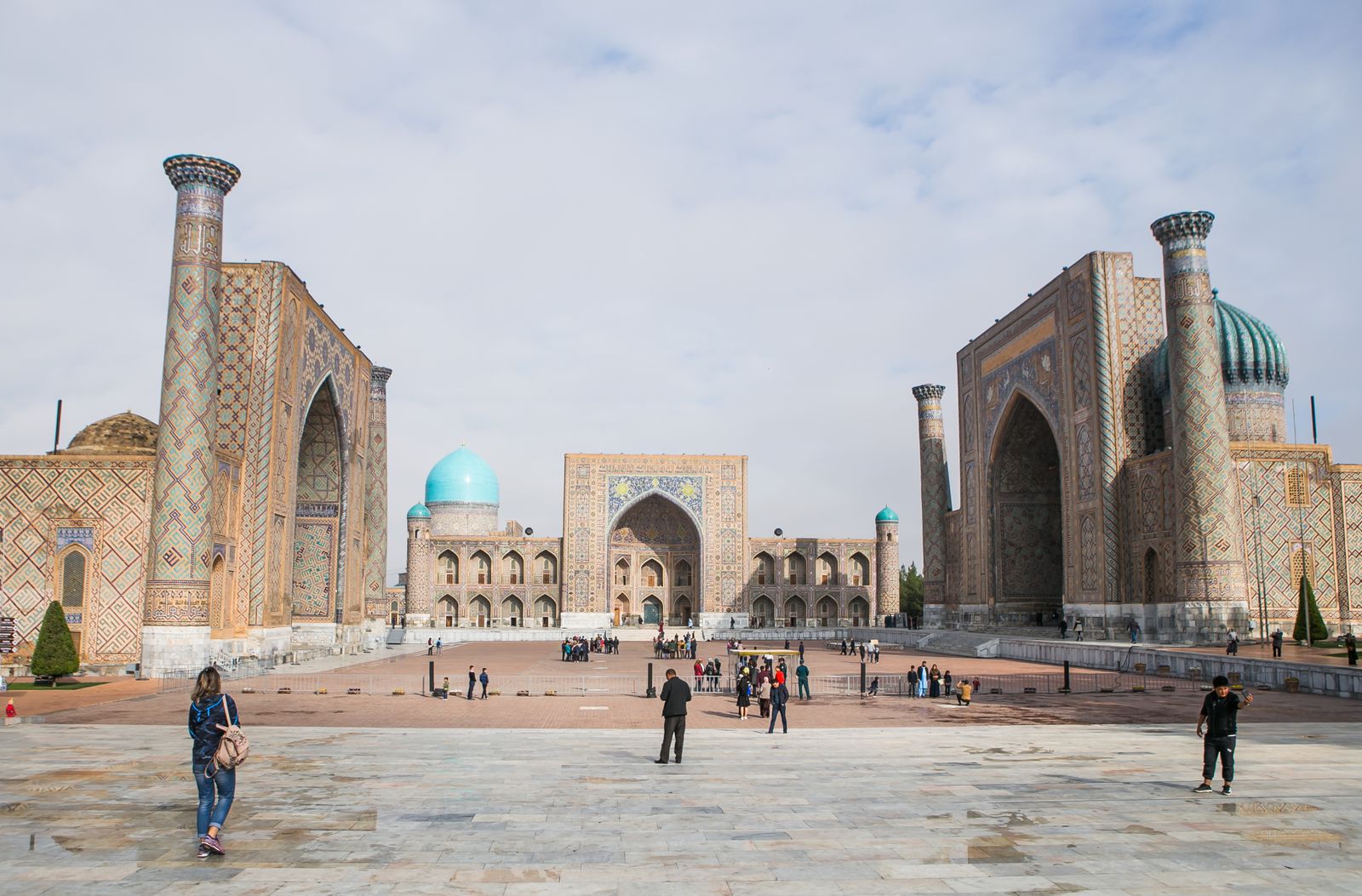 Blue-tiled Islamic architecture with a tall minaret against a clear sky