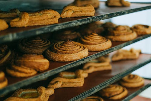 Close-Up Photo of Delicious Cinnamon Rolls on Wooden Rack