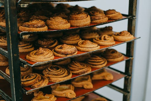Deliciously warm cinnamon rolls freshly baked and cooling on a rack in a bakery setting.