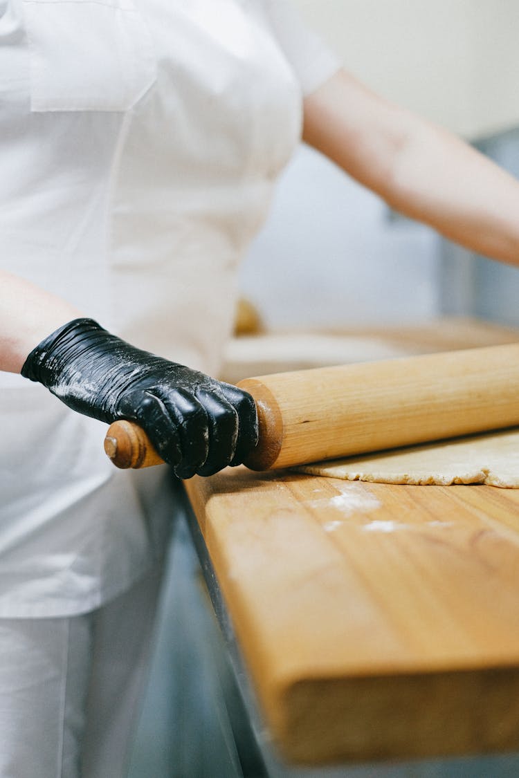 Pastry Chef Flattening A Dough