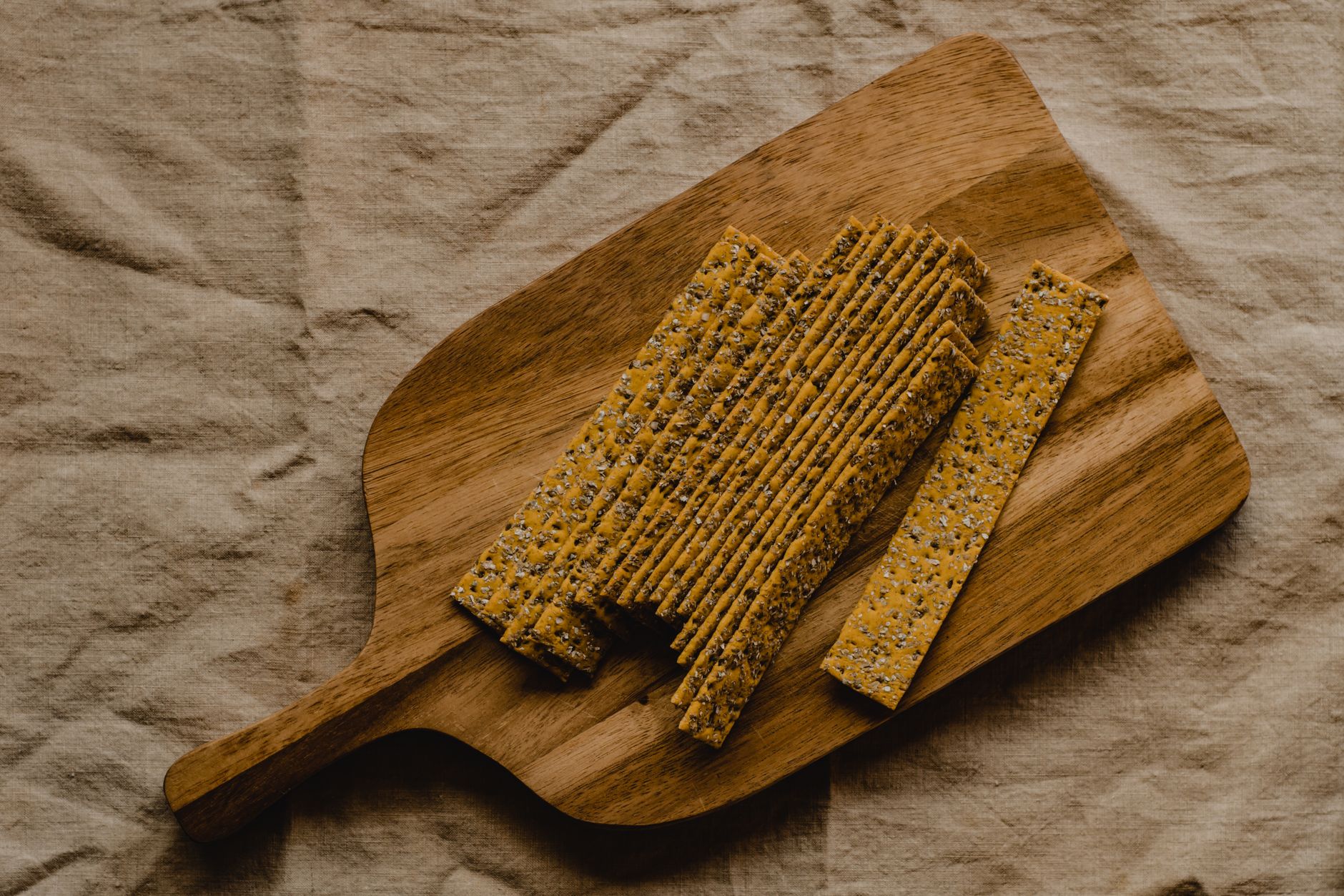 Close-up of crispbread on a wooden board with a rustic background, perfect for food photography.